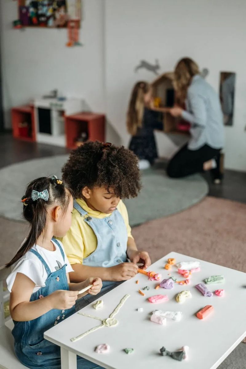 Teachers enthusiastically guiding toddlers in activities